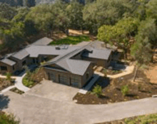 an aerial view of a large house surrounded by trees and a driveway .