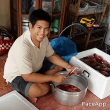 a man is kneeling on the floor next to a pot of blood .