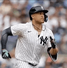 a new york yankees baseball player is running towards home plate during a baseball game .