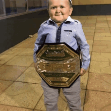 a young boy is holding a world championship plaque