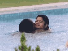 a man and woman are kissing in a pool of water