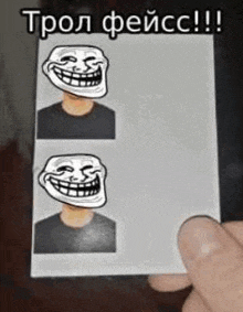 a person is holding a picture of a troll face on a card .