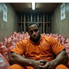 a man in an orange jumpsuit is sitting in a room filled with bottles