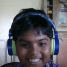 a boy wearing headphones is smiling and looking at the camera