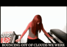 a woman with red hair is playing a piano with the words bouncing off of clouds we were below her