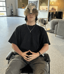 a man wearing a helmet is sitting in a wheelchair with his hands folded