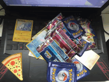 a bunch of pokemon cards are stacked on top of a laptop