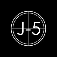 a white circle with the letters j and 5 inside of it on a black background .