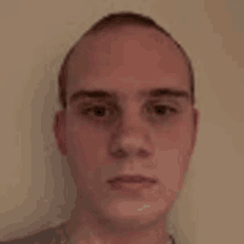 a close up of a young man 's face with a bald head .