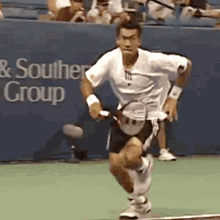 a man is running with a tennis racquet on a tennis court in front of a sign that says & southern group