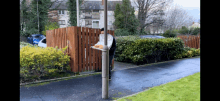 a person standing next to a pole holding a tray of pizza