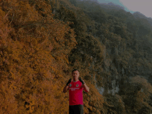 a man wearing a red shirt that says ' united defense team ' on it