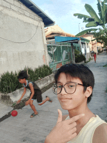 a young boy wearing glasses is giving a thumbs up sign