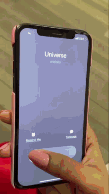 a person is holding a cell phone that says universe mobile