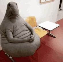 a stuffed animal is sitting on a chair in a waiting room next to a table .