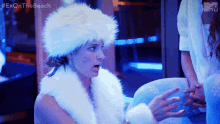 a woman is wearing a white fur hat and a white fur coat with the hashtag exonthe beach