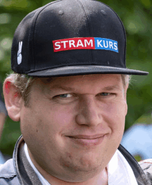 a man wearing a hat that says strom kurs