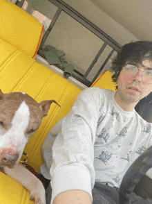 a man with glasses and a dog in the back seat