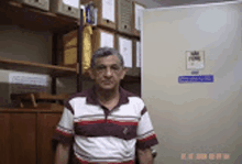 a man in a striped shirt is standing in front of a door with a sign that says ' arquivo ' on it