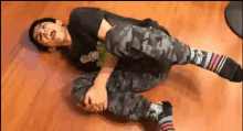 a young man is laying on the floor with his legs crossed and socks on .