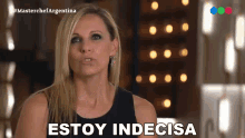 a woman says " estoy indecisa " in front of a blurred background