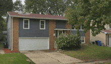 a house with a blue siding and a red roof has a white garage door