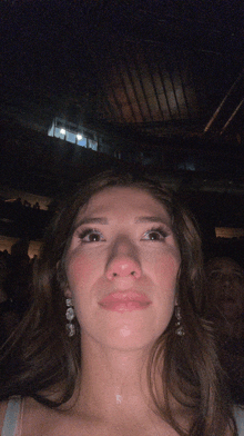 a woman sitting in a dark room with a sign that says ' a ' on it