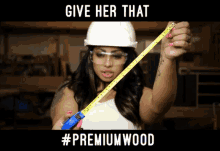 a woman wearing a hard hat and goggles is holding a tape measure with the caption give her that #premiumwood