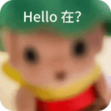 a doll with a green hat and a yellow scarf says hello in chinese