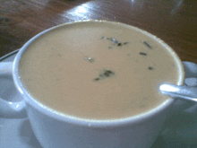 a cup of creamy soup with a spoon in it