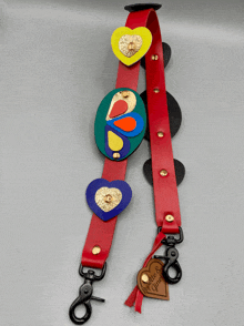 a red leather strap with colorful hearts on it and a tag that says " handmade & handcrafted "