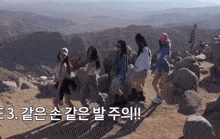 a group of women are standing on top of a rocky hillside with mountains in the background and a caption that says 3