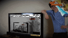 a man is standing in front of a tv screen that says plain