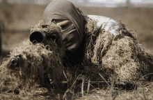 a man in a camouflage suit is holding a gun