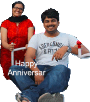 a man wearing an abercrombie & fitch shirt sits next to a woman in a red dress