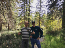 two men giving a thumbs up in a forest with one wearing a patagonia sweater