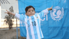 a young boy wearing a blue and white shirt with the number 10 on it