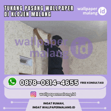 a man is hanging wallpaper on a wall with a phone number