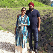 a man in a turban stands next to a woman in a blue tie dye dress