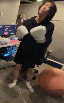 a person wearing boxing gloves standing in front of a computer