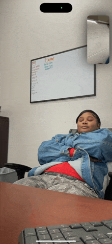 a woman is sleeping in front of a white board that says " home "