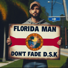 a man holding a sign that says florida man don t fade d.s.k