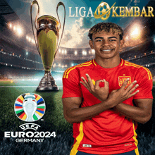 a soccer player in a red and yellow jersey stands in front of a trophy that says euro2024 germany