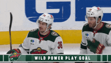 two hockey players on the ice with the words wild power play goal behind them