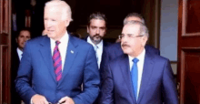 a group of men in suits and ties are standing next to each other .