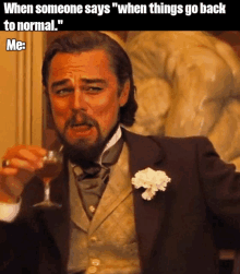 a man in a suit is holding a glass of wine and says when someone says " when things go back to normal "