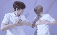 two young men are making a heart shape with their hands and the words dobbyyosh are on the bottom