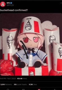 a stuffed doll wearing a kfc bucket hat sits on a box of kfc chicken