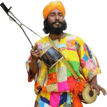 a man with a beard and turban is holding a drum and a bow .