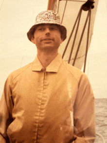 a man wearing a hat and a tan jacket